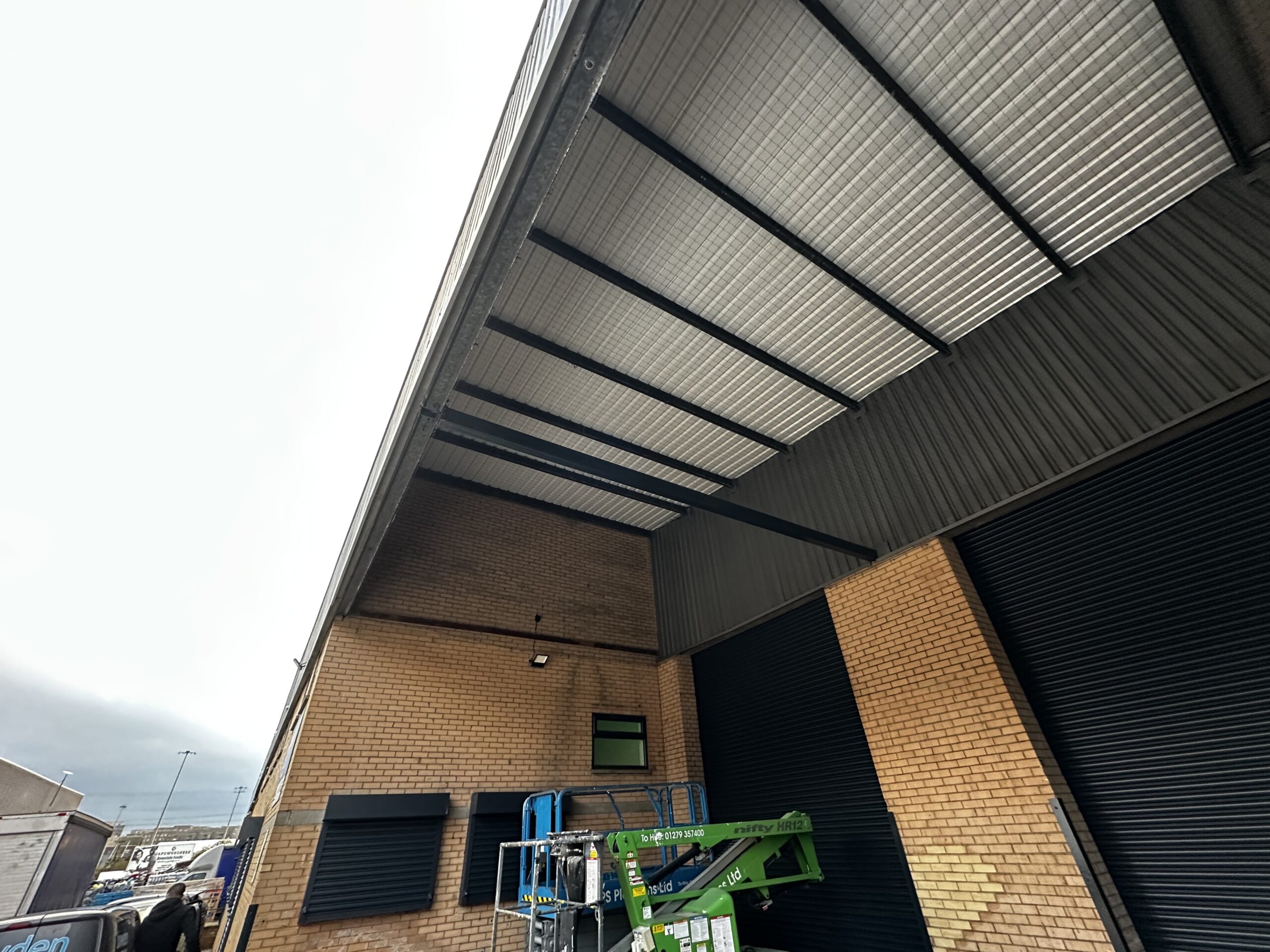 Professional bird netting installation on commercial property canopy structure